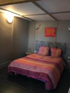 a bedroom with a large bed with a striped blanket at Le Phœnix in Linars +13 photos