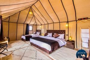 a bedroom with two beds in a tent at Anir Luxury Camp - Gites et Tentes de Luxe in Merzouga
