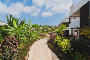a walkway through a garden next to a building at The Grand in Jan Thiel