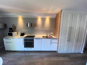 eine Küche mit weißen Schränken und einer Spüle in der Unterkunft BergHerzl - Braunlage in Braunlage + 3 Fotos