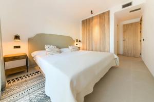 a bedroom with a large white bed with pillows on it at Villas Flamenco Beach Conil in Conil de la Frontera