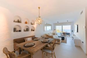 a dining room and living room with a table and chairs at Villas Flamenco Beach Conil in Conil de la Frontera