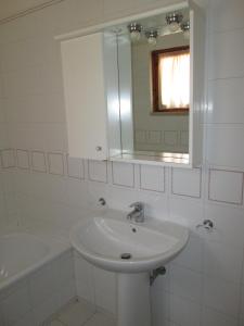 a white bathroom with a sink and a mirror at Appartamenti in Villa e Casali a Giannella in Santa Liberata +45 photos