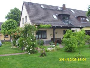 a house with a green yard with flowers at Ferienwohnung "Baum" in Rechlin