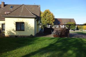 a house with a yard with a green lawn at Ferienwohnung "Meißner" in Rechlin