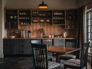 a kitchen with a wooden table and chairs at Cape Panorama Lodge in Panorama +15 photos