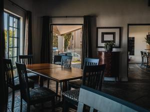 a dining room with a wooden table and chairs at Cape Panorama Lodge in Panorama
