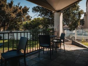a patio with chairs and a table and a fence at Cape Panorama Lodge in Panorama