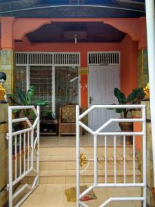 a living room with orange walls and a white fence at Cendana Homestay in Sawahlunto