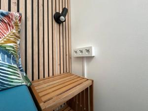 圣丹尼斯StuDio 75 pour 2 personnes avec terrasse - vue mer的木凳在房间的角落 更多18张照片
