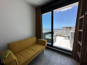 圣丹尼斯StuDio 75 pour 2 personnes avec terrasse - vue mer的带沙发和大窗户的客厅