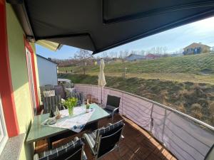 a patio with a table and chairs on a balcony at Fewo Seeschwalbe - Marina Mücheln in Mücheln