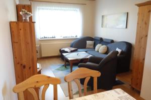 a living room with a blue couch and a table at Ferienwohnung "Meißner" in Rechlin