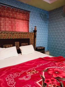 Un dormitorio con una cama con una manta roja. en City Palace Hotel Lahore, en Lahore