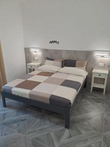 a large bed in a room with two tables at B&B Clarosa in Pizzo