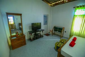 a room with a bedroom with a bed and a television at Janali Homestay in Kandy