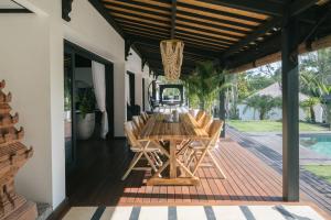 a wooden deck with a table and chairs on it at Villa Puri Greenlot Cemagi in Canggu