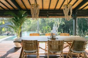 a dining room with a table and chairs on a deck at Villa Puri Greenlot Cemagi in Canggu