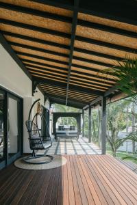 a wooden porch with a bench on a wooden deck at Villa Puri Greenlot Cemagi in Canggu