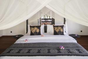a bedroom with a large bed with a canopy at Villa Puri Greenlot Cemagi in Canggu +85 photos