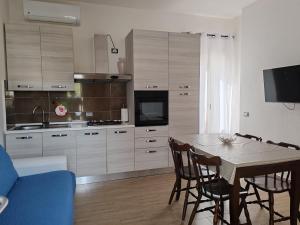 a kitchen with a table and a blue couch at CASA FLORIS in Tertenìa +13 photos