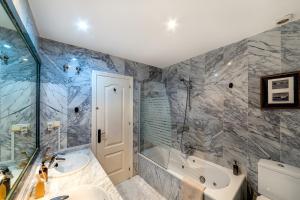 ein Badezimmer mit Badewanne und Waschbecken in der Unterkunft Luci by The Sea in La Herradura + 30 Fotos