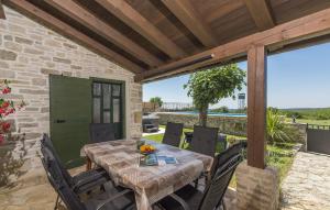 Una mesa y sillas de madera en un patio. en Villa Ana Rita for 6 people - beautiful rustical villa with heated pool & jacuzzi in Central Istria, en Kanfanar
