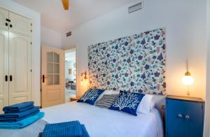 Schlafzimmer mit einem Bett mit einem blauen und weißen Kopfteil in der Unterkunft Luci by The Sea in La Herradura