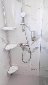 a white bathroom with a shower with two sinks at Spacieux T3 Sète, parking, 10 min à pied gare et centre ville, wifi, clim in Sète