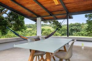 a white table with chairs and a hammock at Casa Algarrobo relaxing farm stay in Puerto Rico in Cerro Gordo