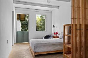 a bedroom with a bed and a window at Casa Algarrobo relaxing farm stay in Puerto Rico in Cerro Gordo