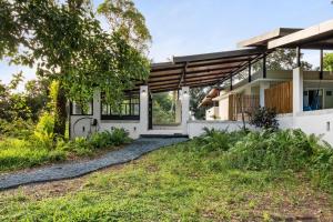 a house with a large window and a yard at Casa Algarrobo relaxing farm stay in Puerto Rico in Cerro Gordo