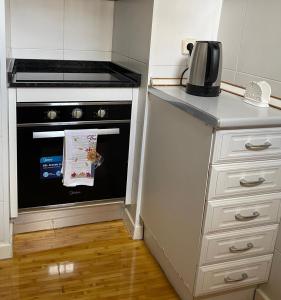 a small kitchen with a stove and a microwave at Studio 110 in Luanda