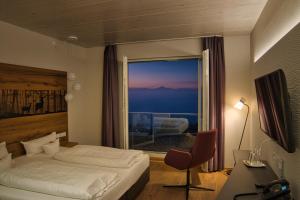 a bedroom with a bed and a window with a view at Hotel Schönbuch in Pliezhausen +120 photos