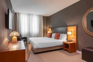 ein Hotelzimmer mit einem Bett, einem Tisch und einem Spiegel in der Unterkunft Acta Sant Just in Sant Just Desvern