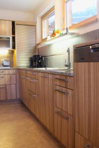 a kitchen with wooden cabinets and a sink at Stöcklgut Ferienhaus in Niedernsill