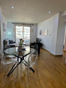 ein Wohnzimmer mit einem Glastisch und Stühlen in der Unterkunft Ithaki Phinikoudes Apartment No. 205 in Larnaka