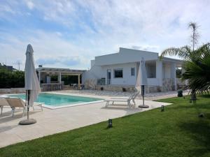 a house with a swimming pool and two umbrellas at Malia Holiday Villa in Conversano