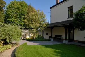 una casa con un banco en el patio en Guesthouse Les Tilleuls en Fleurus