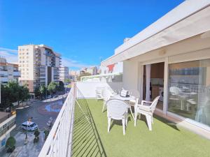 a balcony with white chairs and a table at Atico A Cartagena centro historico Parking in Cartagena
