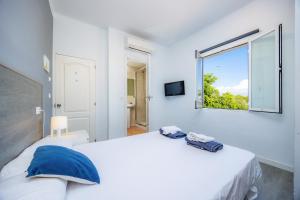 坎帕斯蒂利亚Mallorca Rooms Can Pastilla的一间带大床和窗户的白色卧室