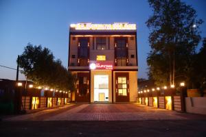 a building with a sign on top of it at night at The Rajputana Palace in Phanda