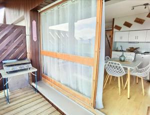 a balcony with a table and a view of a kitchen at Duplex au cœur de la station in Ustou