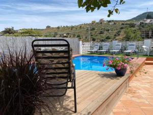 a chair sitting on a deck next to a swimming pool at Casa Luna in Tolox