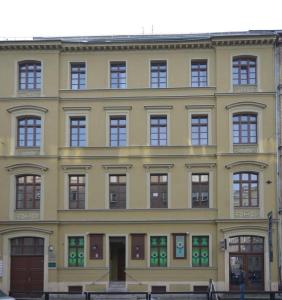 a large yellow building with many windows at Rooms Center - dworzec PKP, rynek Wrocław in Wrocław
