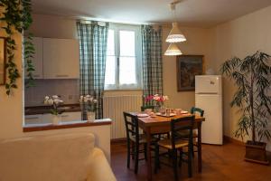 a kitchen and dining room with a table and a refrigerator at Casa La Lilla in Cascina
