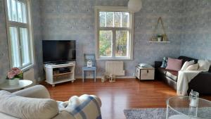 a living room with a couch and a tv at Villa and cottage by the sea in Sunnanberg