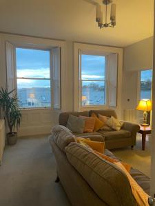 a living room with a couch and two windows at Number 5 in Beadnell