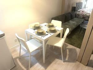 einen weißen Tisch und Stühle im Wohnzimmer in der Unterkunft Résidence Champenoise 1 , Troyes - France in Troyes