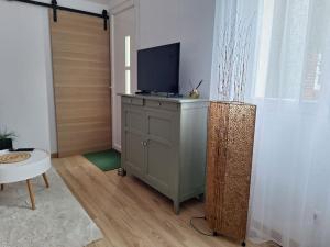 a living room with a television on a dresser at Charmante maisonnette équipée in Caudebec-lès-Elbeuf